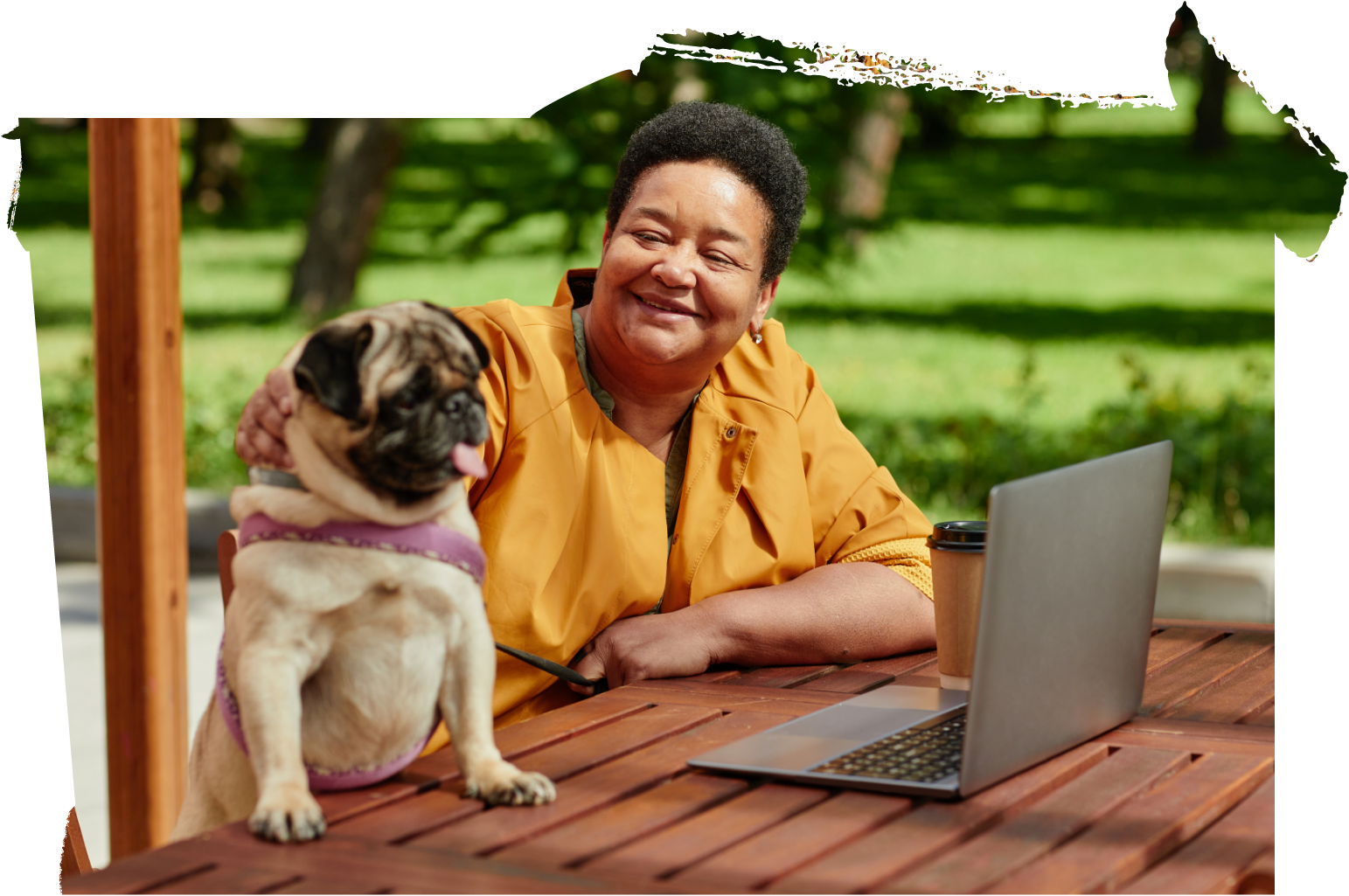 woman and pug dog in park with laptop